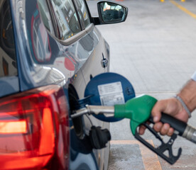 Gasoline station attendant fuel up the car , man pouring petrol oil his car in the gas station