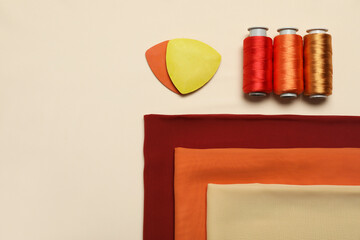 Flat lay composition with sewing threads on beige background, space for text