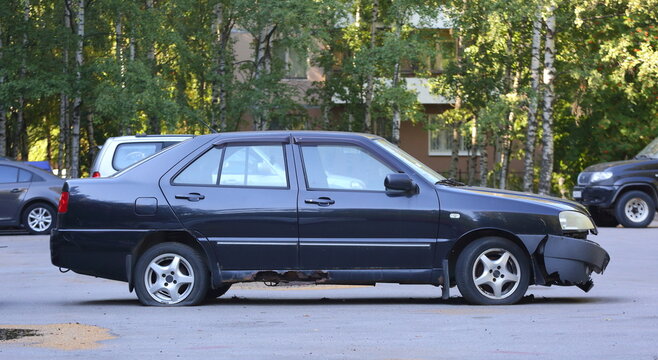 An old rusty broken black car is parked in the courtyard of a residential building, Tovarishchesky Prospekt, St. Petersburg, Russia, August 2021