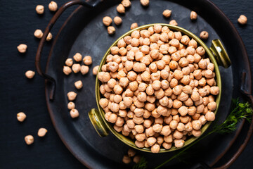 Food ingredient concept rew Chickpeas in green bowl with black background with copy space
