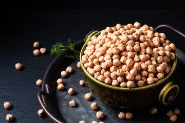 Food ingredient concept rew Chickpeas in green bowl with black background with copy space