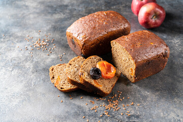 Two rye rectangular loaves of sweet bread with dried apricots and plums.
