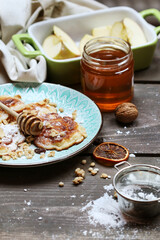 Apple fritters with powdered sugar, honey and muesli.
