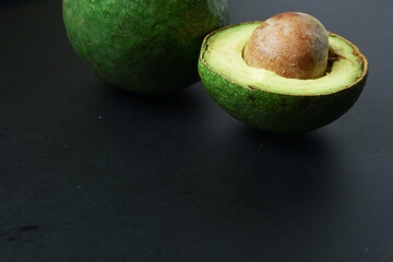 half avocado on the black board table background and blank space for the concept of healthy food