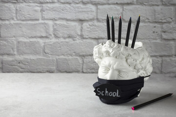 Chalk lettering School. Plaster stand of David's head for office and school supplies on a light...