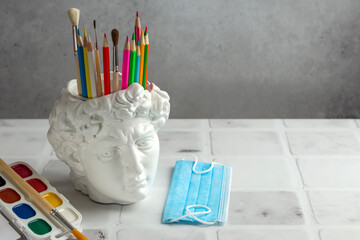 David's head plaster stand for office, creative and school supplies on a light background....