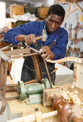 Portrait of furniture restorer in process of renewing vintage chair at workshop