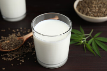 Glass of fresh hemp milk on wooden table