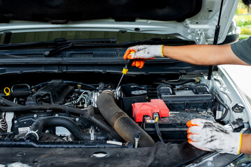 Mechanic using screwdriver to inspect car