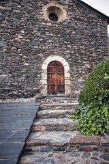 Fototapeta na wymiar Old door of a small town in the Pyrenees of Andorra. Mountain architecture. Rock, stone and wood
