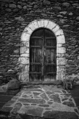 Fototapeta na wymiar Old door of a small town in the Pyrenees of Andorra. Mountain architecture. Rock, stone and wood