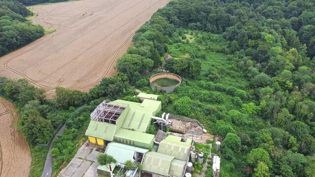 Aerial reverse birdseye view over the now-abandoned Thruxted Mill near Canterbury Kent - A former animal processing plant used for rendering cattle during the height of the BSE Mad Cow Disease Crisis
