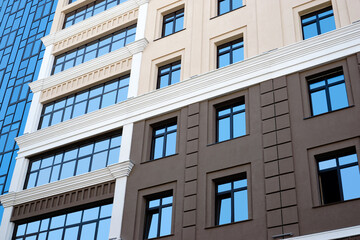New high rise office building close up. Multistory house with glass facade.
