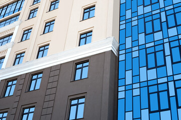 New high rise office building close up. Multistory house with glass facade.