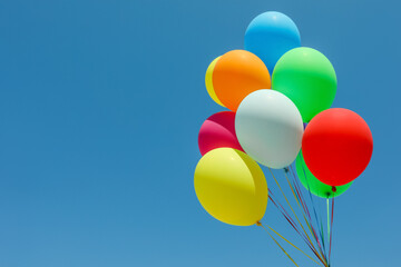 Bunch of colorful balloons against blue sky. Space for text