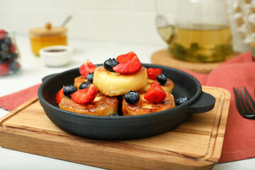Delicious cottage cheese pancakes with fresh berries and honey served on white table