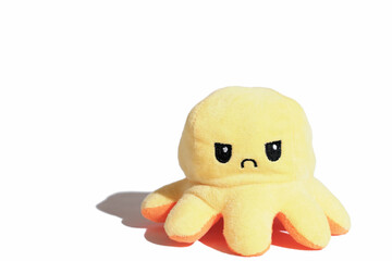 yellow angry toy octopus isolated on white background. sad or moody kids concept. children...