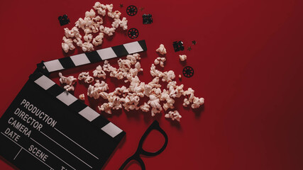 movie clapperboard with popcorn  on a red background. flatlay. copy space