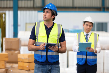 factory worker or engineer using tablet for preparing a job in warehouse storage
