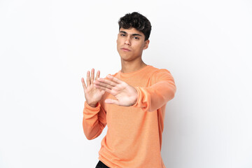 Young man over isolated white background nervous stretching hands to the front