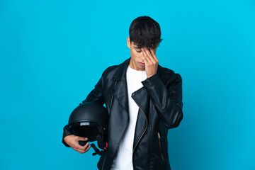 Young man with a motorcycle helmet over isolated blue background with tired and sick expression