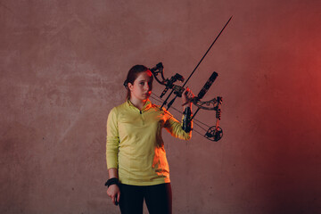 Archer woman with modern block sport bow and arrow indoor.