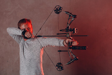 Archer man with modern block sport bow and arrow.