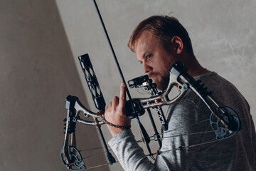 Archer man with modern block sport bow and arrow.