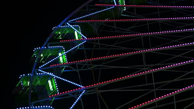 Noria atracci&oacute;n de feria por la noche con luces de colores.