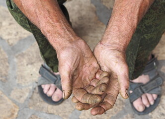 The hands of a senior handyman man, with calluses and cracks. Agricultural manual labor.