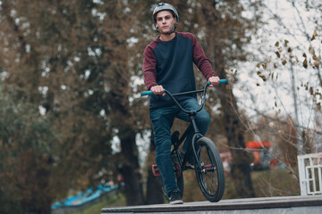 Professional young sportsman cyclist riding mini bike at skatepark