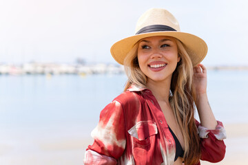 Young pretty blonde girl on the beach in summer holidays