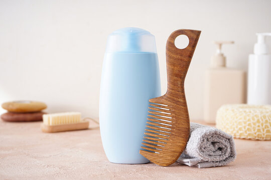 Shampoo, hair brush and towel on a beige background.