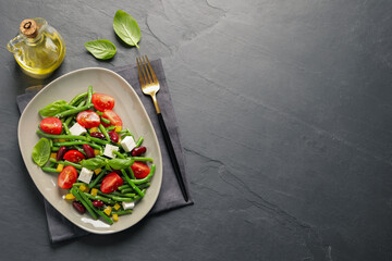Tasty salad with green beans served on black table, flat lay. Space for text