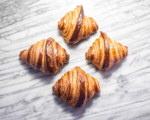 Four Croissants on White Marble