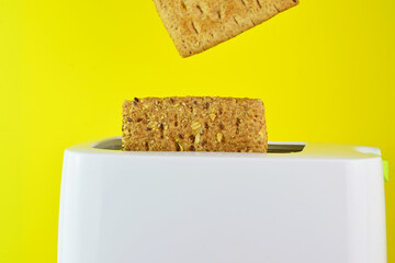 Toasts and toaster on yellow background.