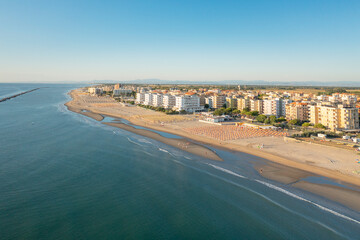 Aerial shot of sandy beach with umbrellas and gazebos.Summer vacation concept.Lido Adriano town,Adriatic coast, Emilia Romagna,Italy.