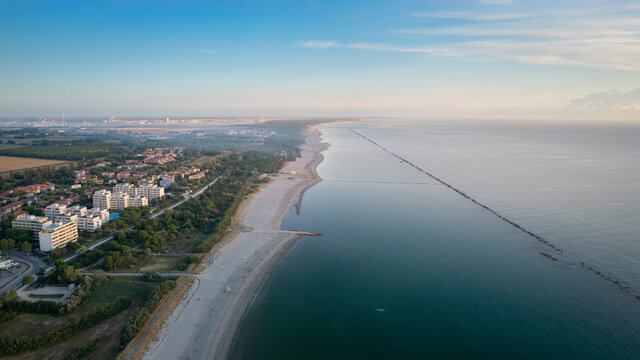 Aerial shot of sandy beach with umbrellas and gazebos.Summer vacation concept.Lido Adriano town,Adriatic coast, Emilia Romagna,Italy.