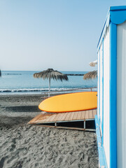 Closeup view of a yellow surfing board on a wooden deck at the beach on a sunny day