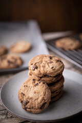 stacked chocolate chip cookie in dark background