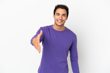 Fototapeta premium Caucasian handsome man over isolated white background shaking hands for closing a good deal