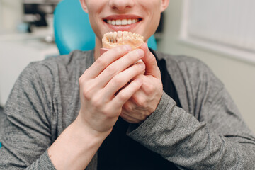 Dentistry. Dentist and patient. Dental clinic. Patient with implant model.