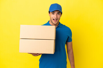Fototapeta na wymiar Delivery man over isolated yellow wall with surprise facial expression