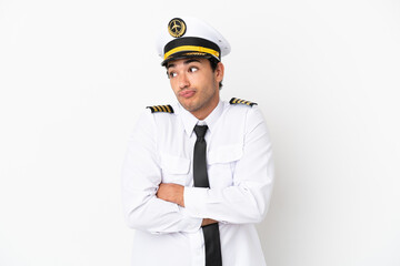 Airplane pilot over isolated white background making doubts gesture while lifting the shoulders