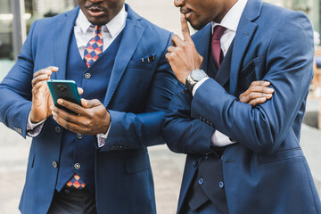 Meeting of two partners black african american businessman in suits and glasses outdoors