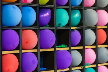 Multi-colored inflatable balls stand in square cells to defeat them with a dart.