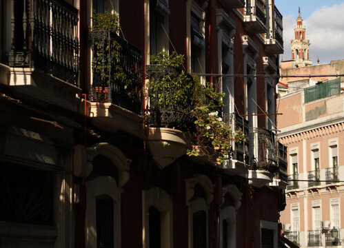 Facade of an old apartment building with balconies decorated with plants
