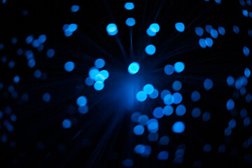 Blue abstract particles and lines with bokeh and blur in dark background.