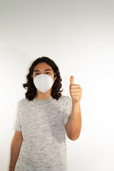 Hispanic man with long hair wearing a kn95 face mask on a white background with a thumb up