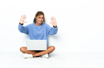 Young blonde Uruguayan girl with the laptop isolated on white background counting ten with fingers